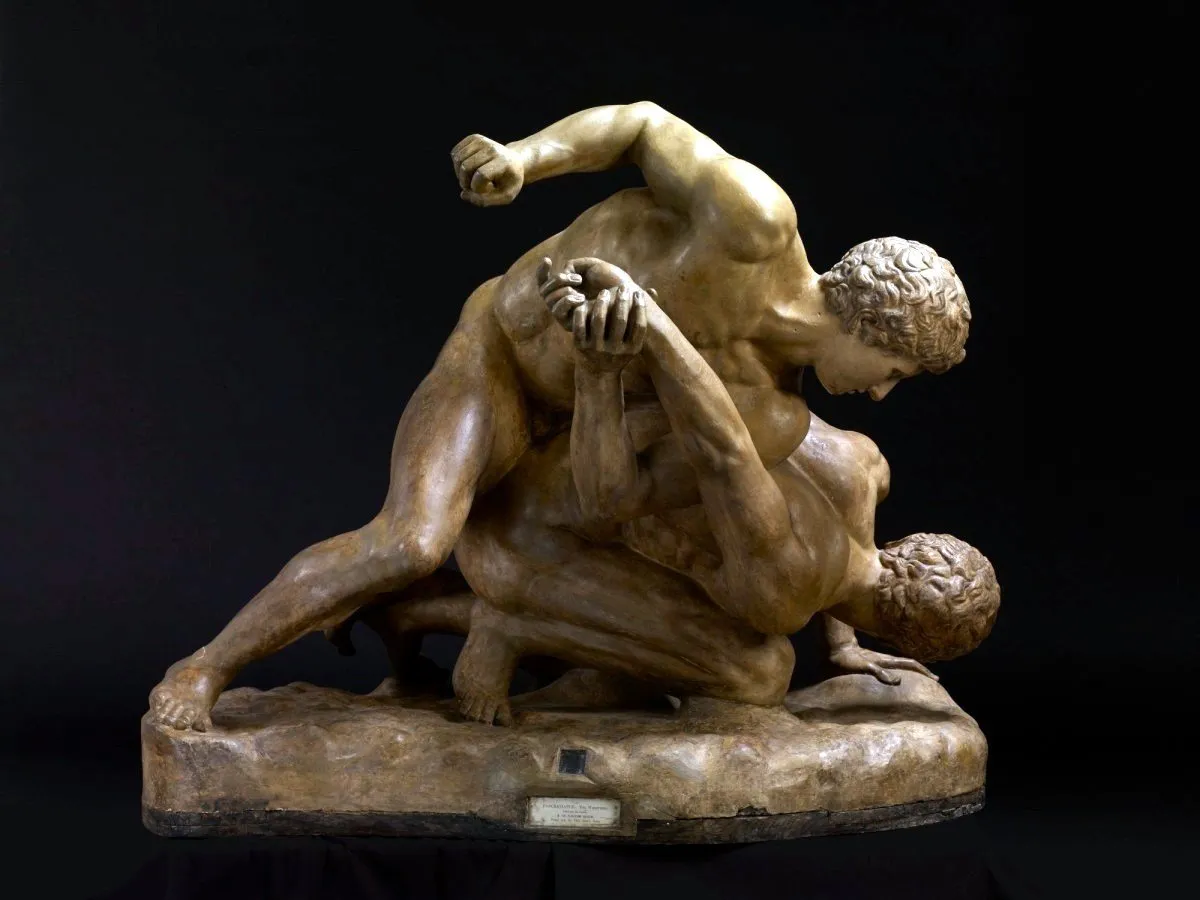 Ancient bronze statue of two men wrestling