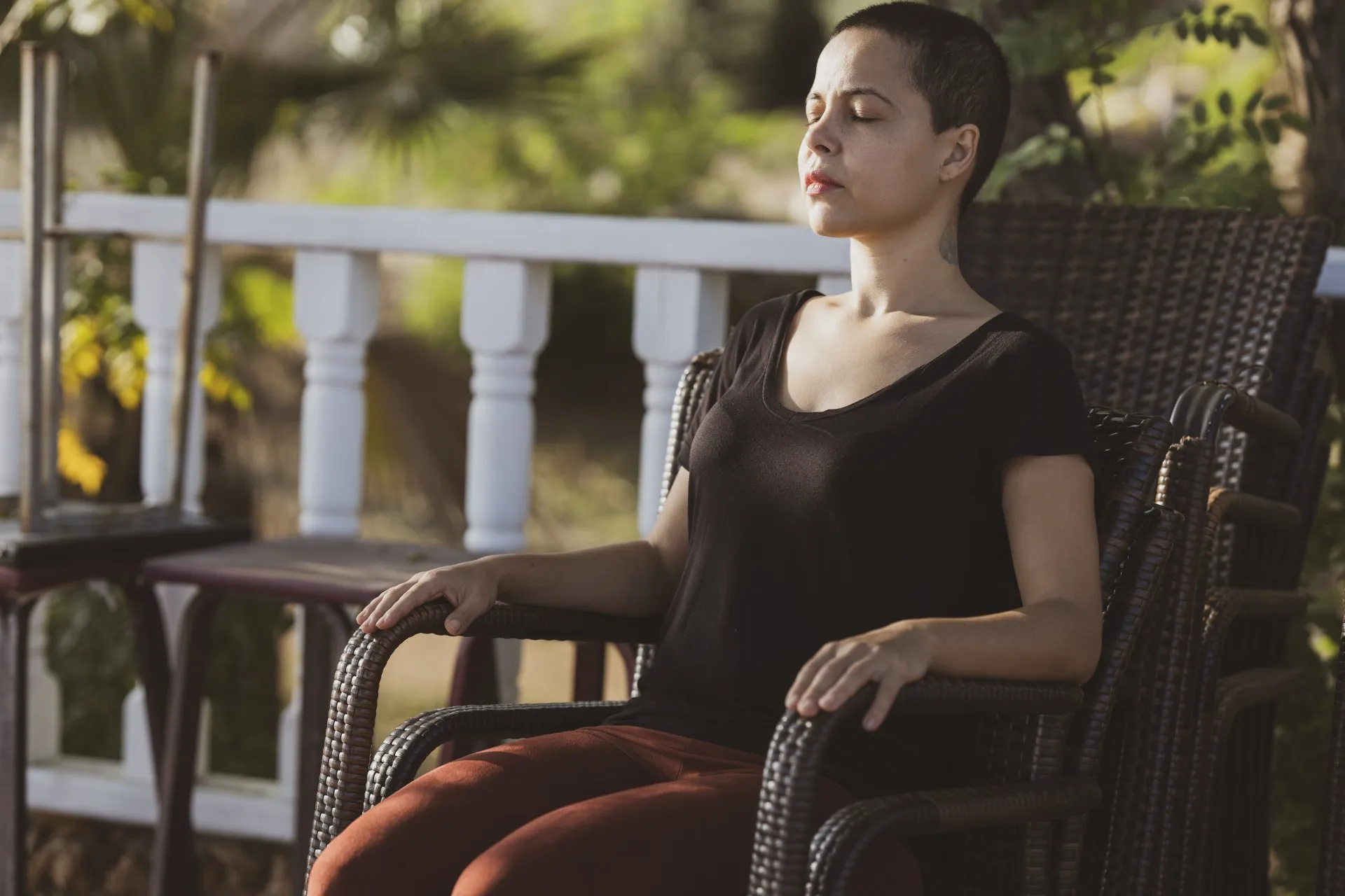 Woman sitting in chair with her eyes closed seems to be meditating 