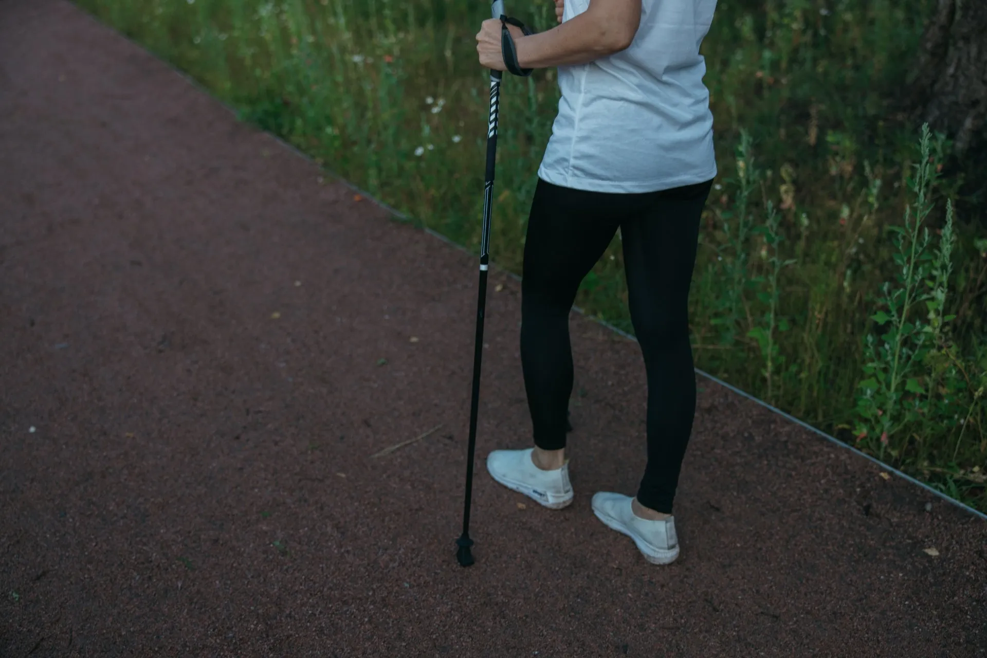 Woman with a walking stick on a walking path